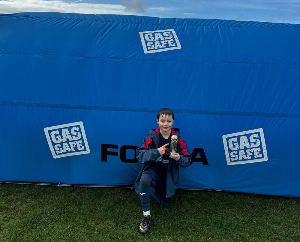 Team member in front of portable shelter with trophy