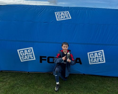 Team member in front of portable shelter with trophy
